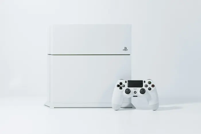 White original PlayStation 4 console with a matching DualShock 4 controller